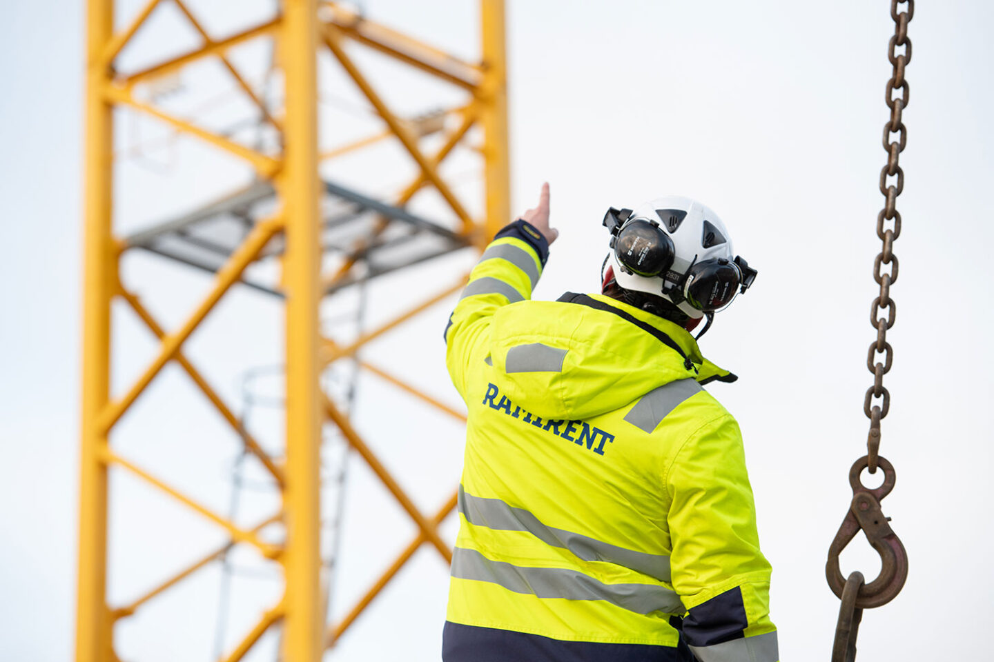 Mies osoittaa torninosturia