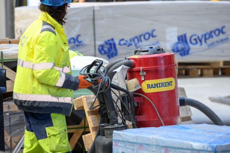 Henkilö kuljettaa punaista teollisuusimuria.