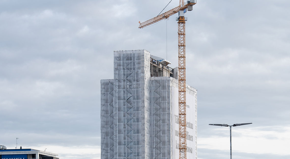 Rakennustelineet ja telinepeitot sekä torninosturi rakennustyömaalla Keilaniemessä