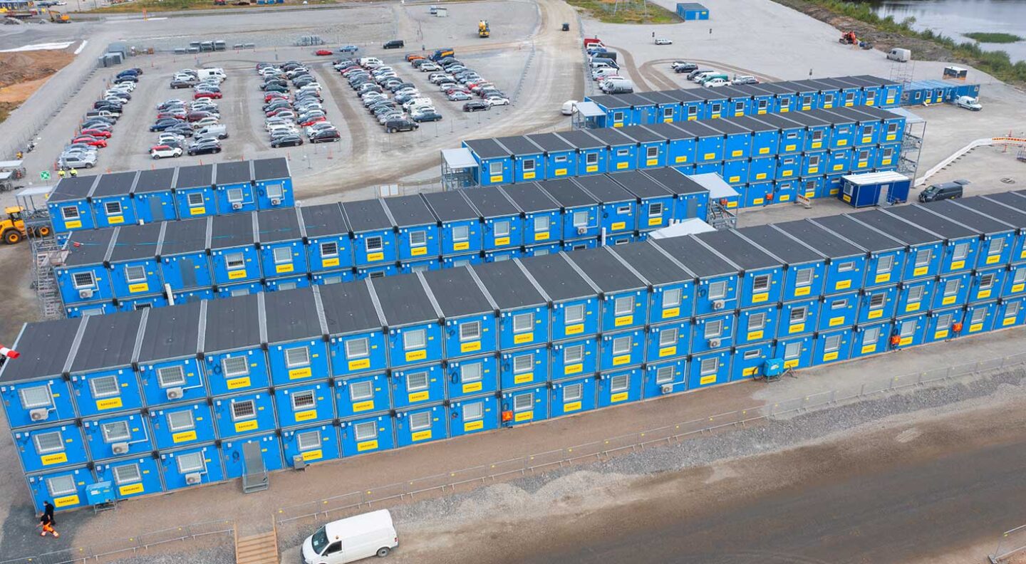 Ramirentin sinisiä työmaatiloja kolmessa kerroksessa useassa rivissä työmaalla.