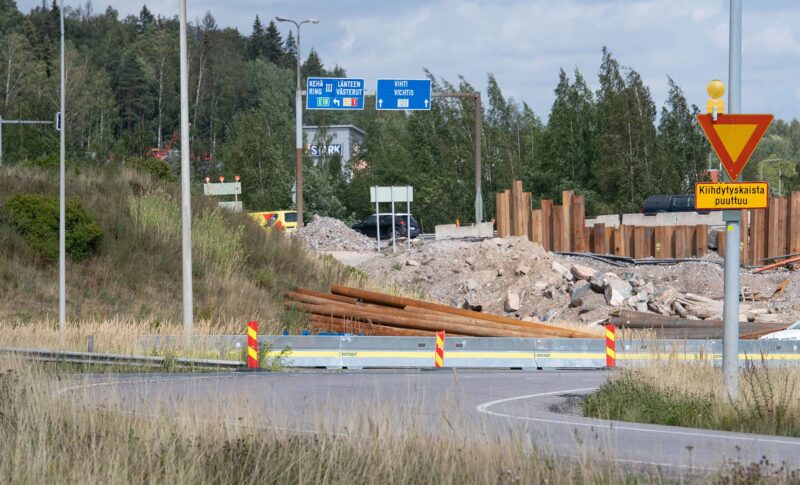 Tien mutka, joka on suojattu liikennekaiteella ja sulkulamelleilla.