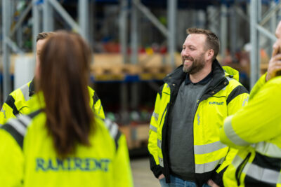 Kolme keltaisiin työtakkeihin pukeutunutta henkilöä ryhmässä.