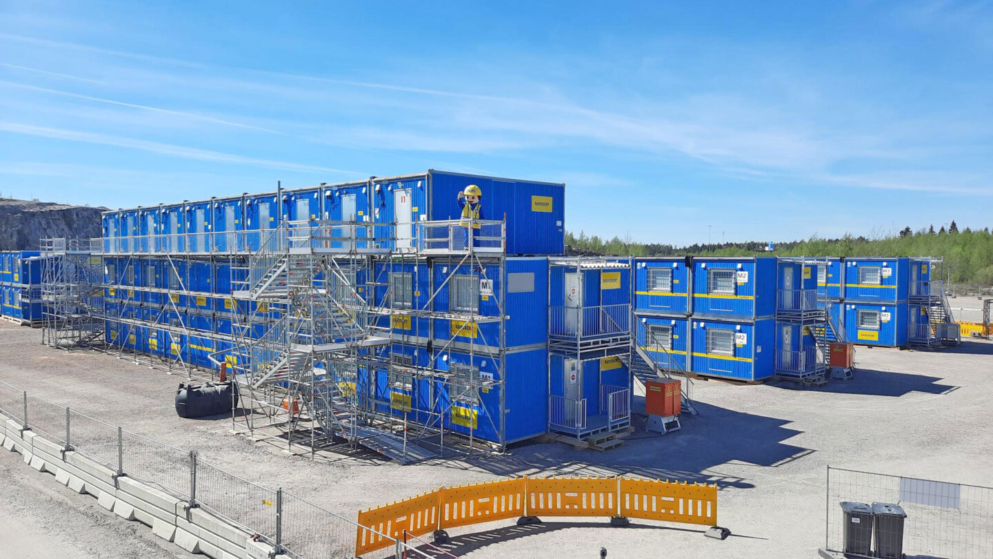 Sinisiä työmaatiloja kahdessa ja kolmessa kerroksessa sekä niihin johtavia porrastorneja.