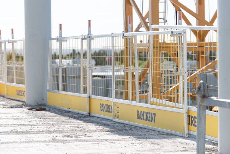 Rakennustyömaalla oleva tasanne jonka reunassa on metalliset suojakaiteet.