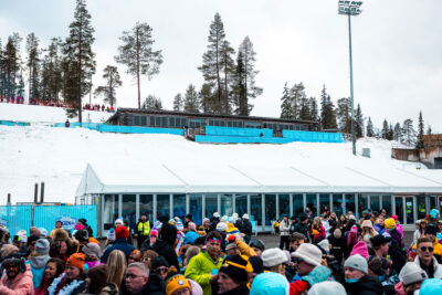 Ison tapahtumateltan edessä on paljon ihmisiä talvisessa maisemassa.